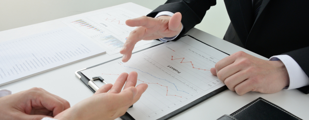Consultores medíocres discutem gráficos de desempenho e indicadores empresariais durante reunião estratégica para análise de resultados e planejamento de ações.