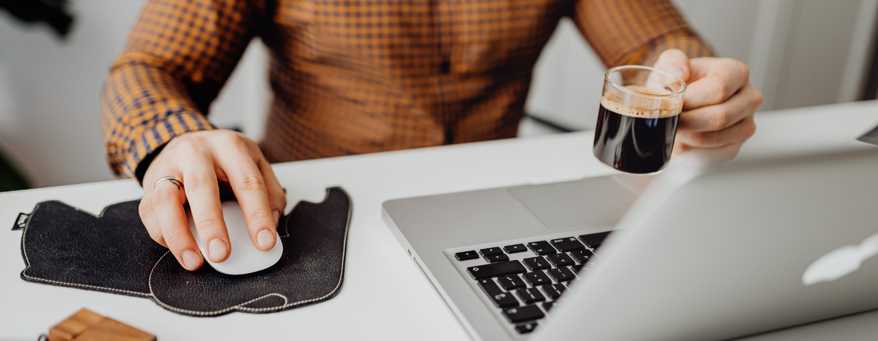 Pessoa utilizando um notebook e segurando uma xícara de café durante uma pausa no trabalho, representando a gestão de energia e a recuperação do foco para aumentar a produtividade.